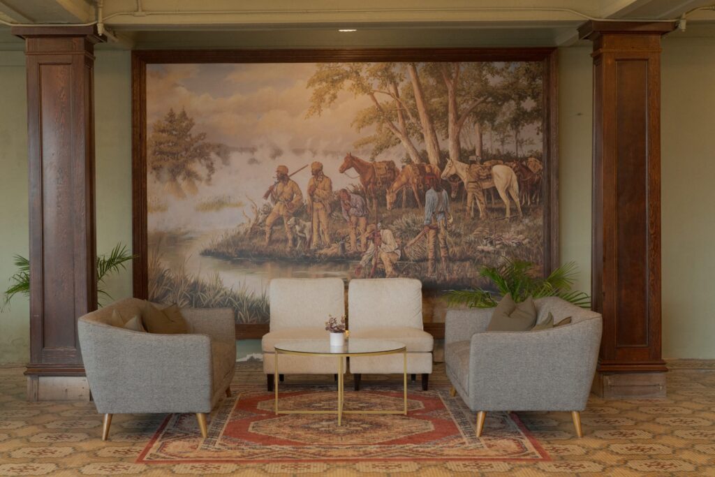 Chairs and table with art wallpaper in background at Hot Lake Lodge.