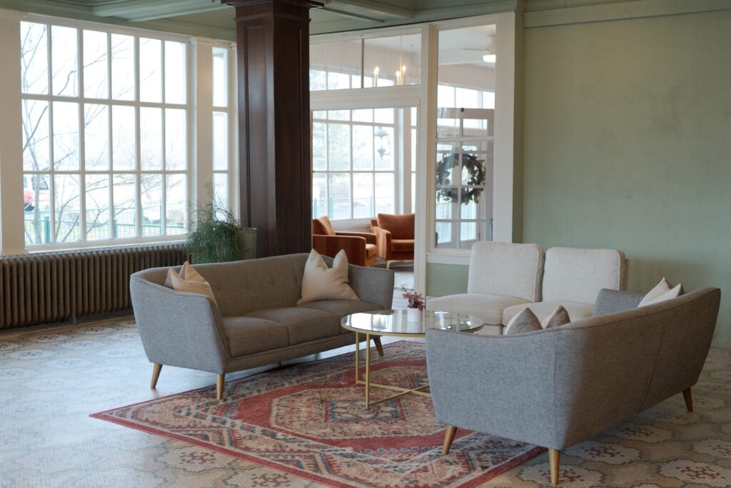 Comfortable sofa and cushion arrangement on a rug with big transparent windows.