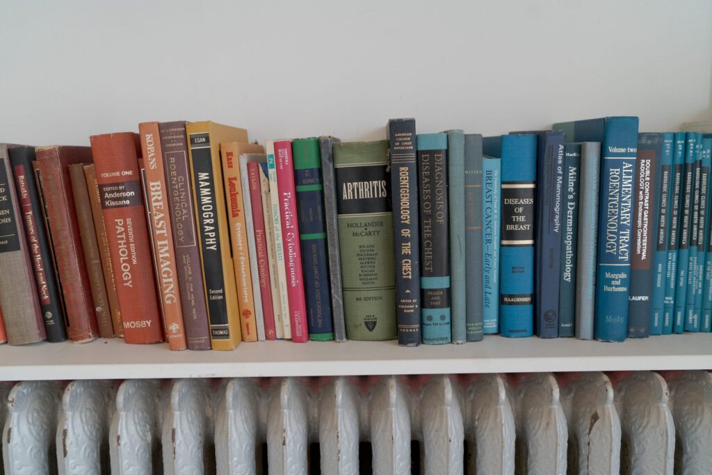 Books placed vertically on a white wooden shelf