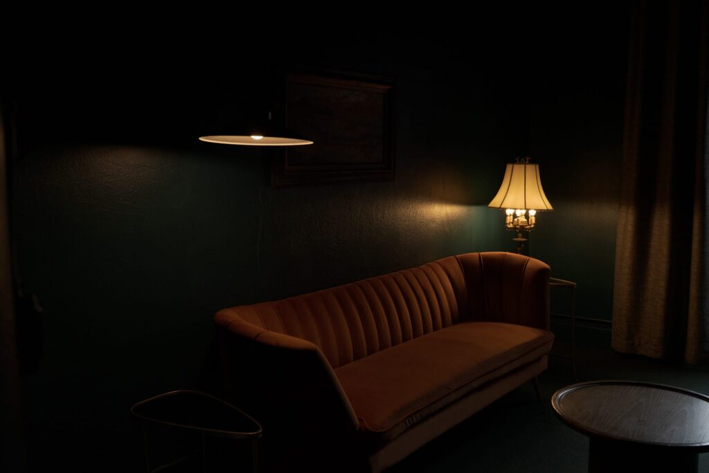 Dimly lit room by a modern wall-mounted lamp on the left and a classic table lamp on the right.