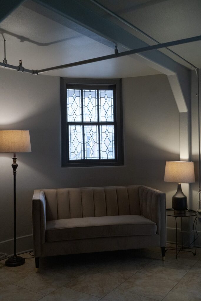 Gray rectangle sofa with soft lighting lamps on either sides.