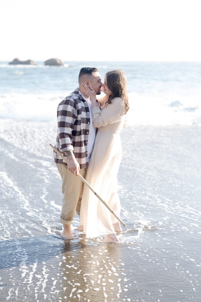 Cute lady in white gown holds her man for a kiss at Bodega Bay, Sonoma County.