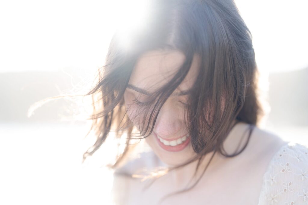 Lady smiles while sunkissed at the beach 