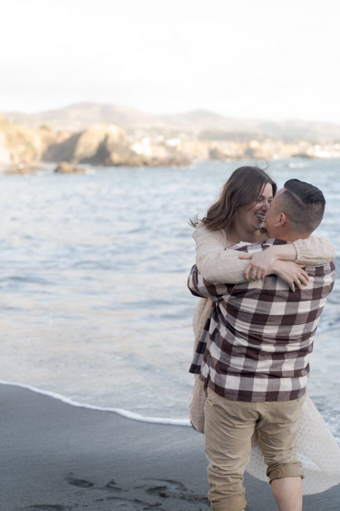 Newly engaged couple at Bodega Bay embrace and snuggle after their union.