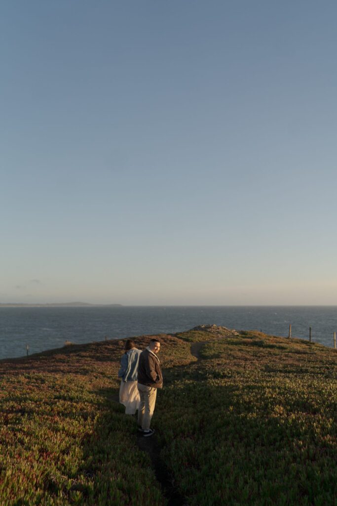 Newly engaged couple walk through Bodega Head Trail.