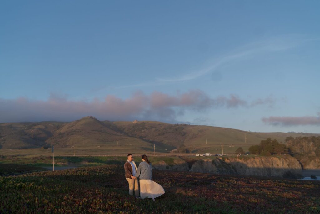 Couple hold hands during sunset at Bodega Bay