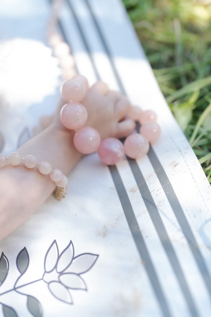 Cute baby hand holds a bracelet made of beads.