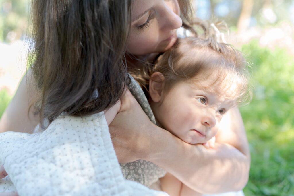 Woman lovingly embraces her daughter.