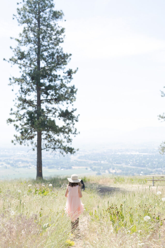 Little girl wears a hat and walks into the fields in La Grande.