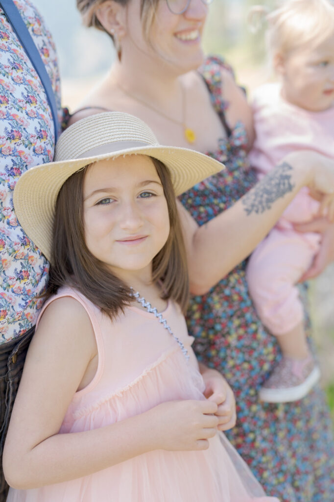 Little girl wearing a khaki hat looks at Robin Jolin's camera.