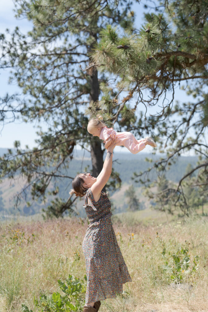 Mother hoists her baby in the air in La Grande.