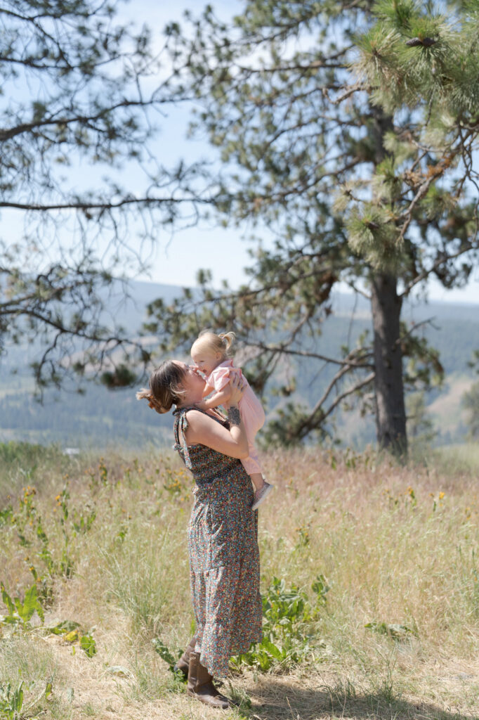 Mother lifts her baby and snuggles.