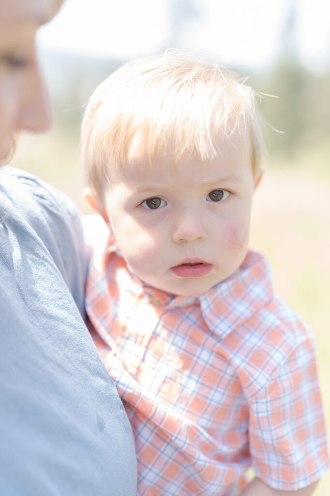 Mom holds her cute son with baby blond hair.