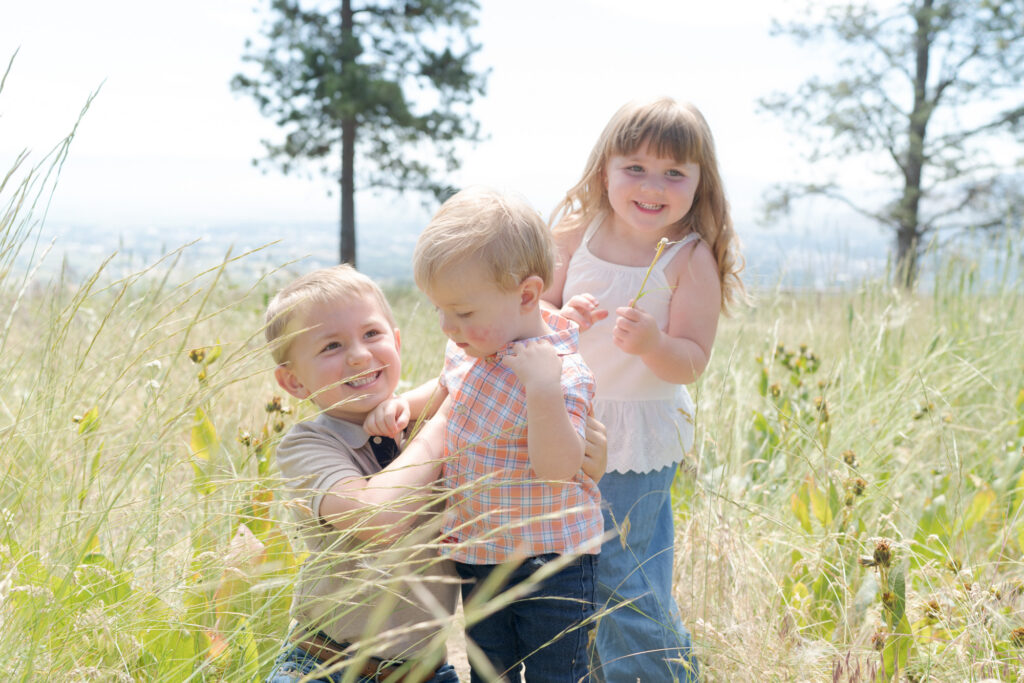 Children play in the tall grasses of La Grande.