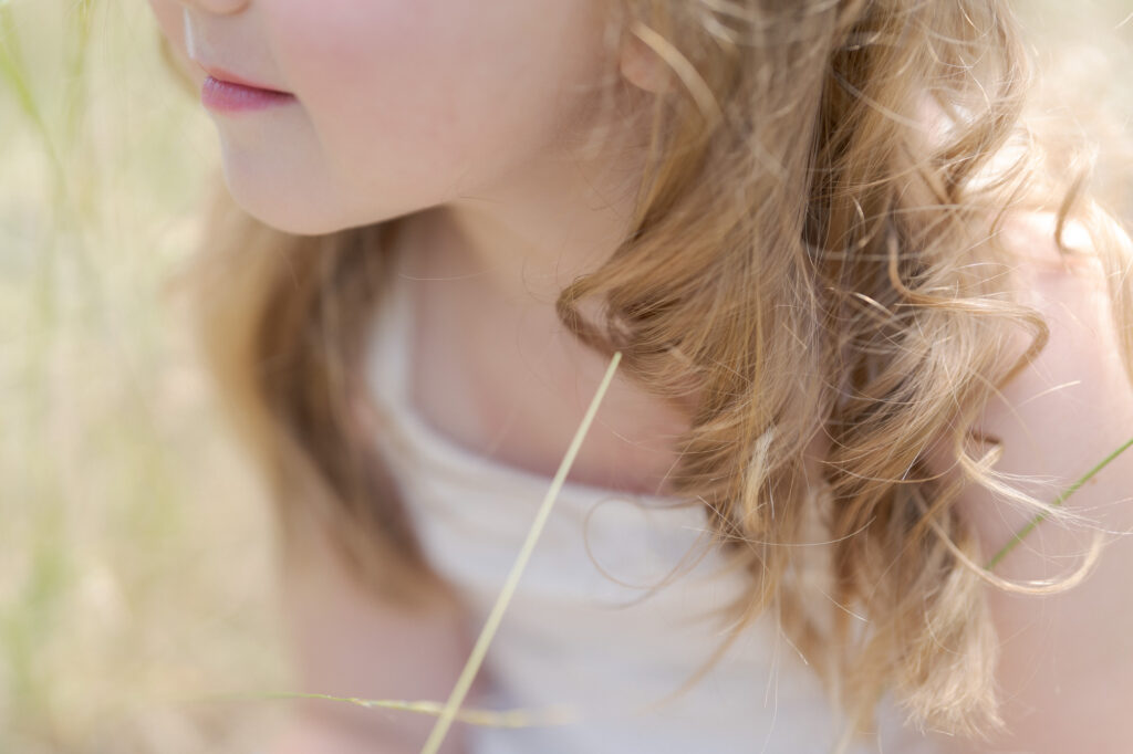 Professional Family Photographer Robin Jolin subtly captures a little girl and her blond hair.