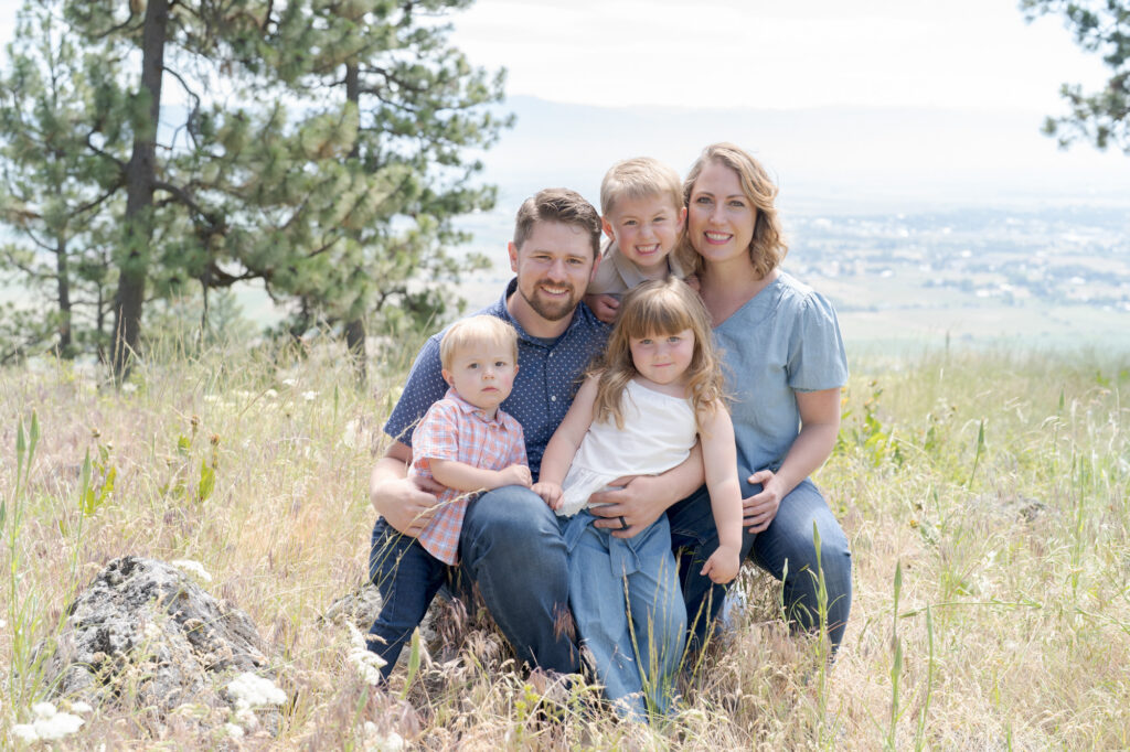 Family of five posing for a portrait in a serene outdoor setting