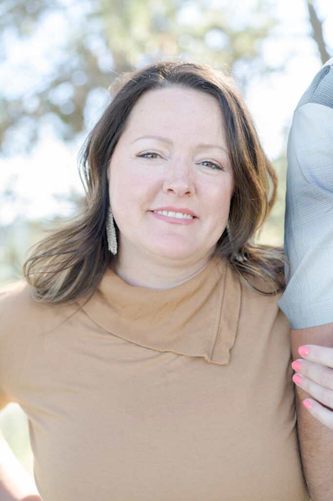 Portrait of a middle-aged lady in a light brown dress.