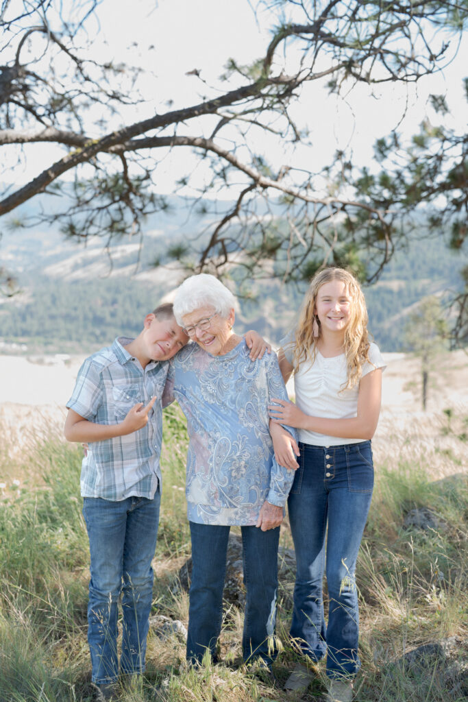 Teen girl and her little brother hold their grandma lovingly.