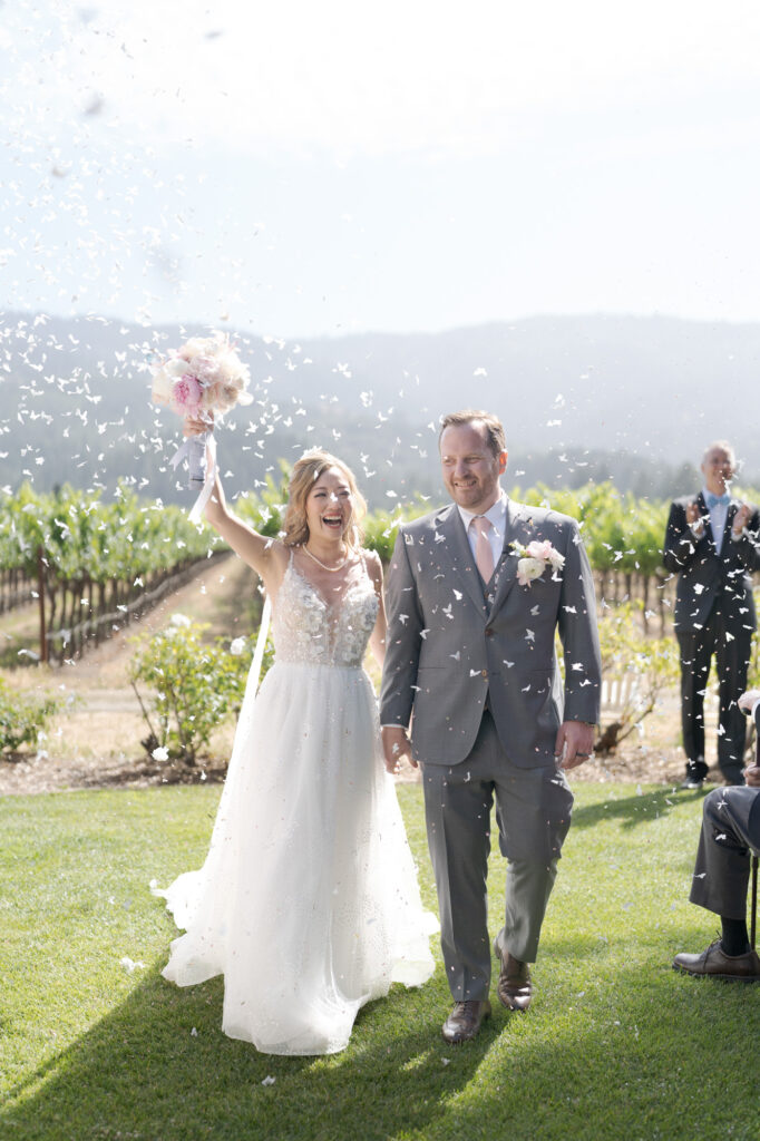 Overjoyed bride and groom walk back up the aisle.