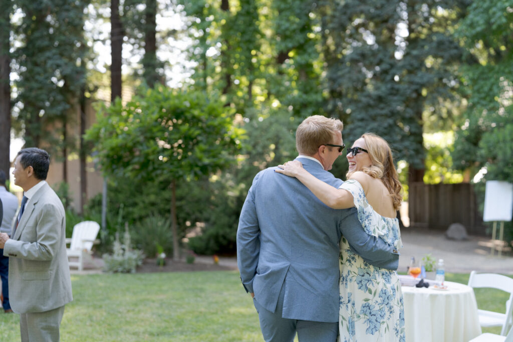 Guests wearing black sunglasses mingle at the cocktail hour.