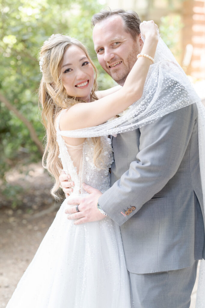 Beautiful bride and her husband embrace for a photo.