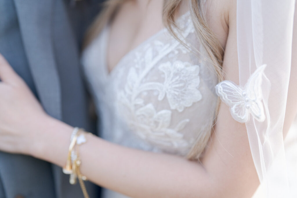 Bride in a wedding gown with fower petals and butterfly design.