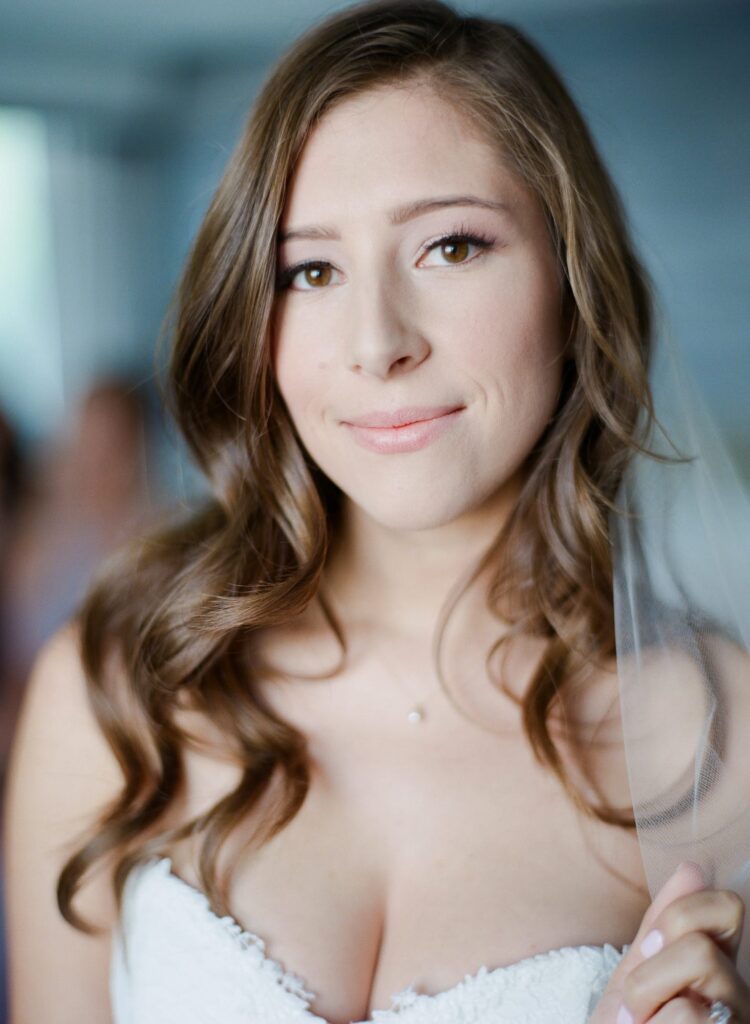 Bride in white wedding gown looks at Robin Jolin's camera.