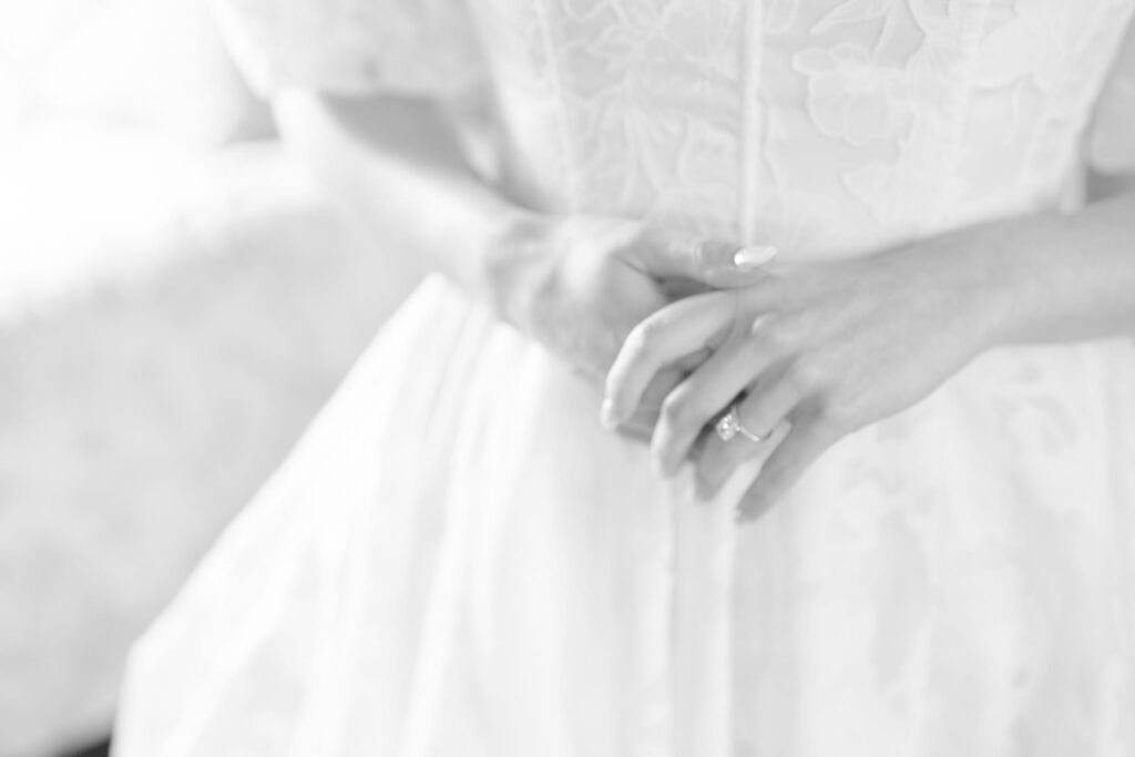 Close up of a bride-to-be in her wedding gown wearing her wedding/ engagement ring.