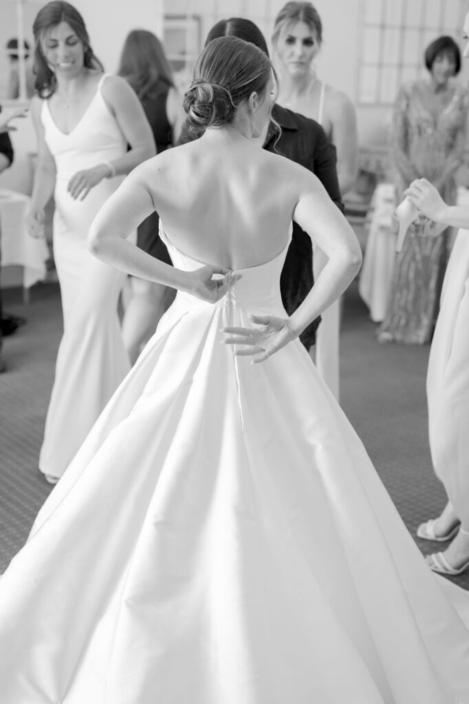 Bride puts on her graceful white wedding gown.