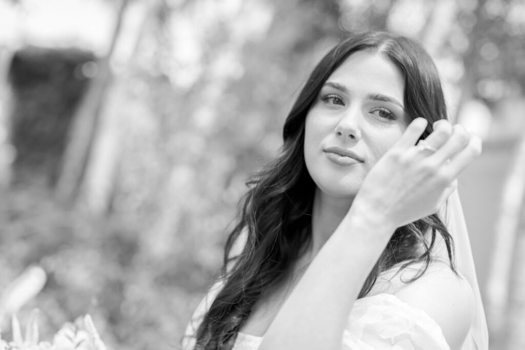 Beautiful bride to be in her wedding gown flexes her engagement ring.