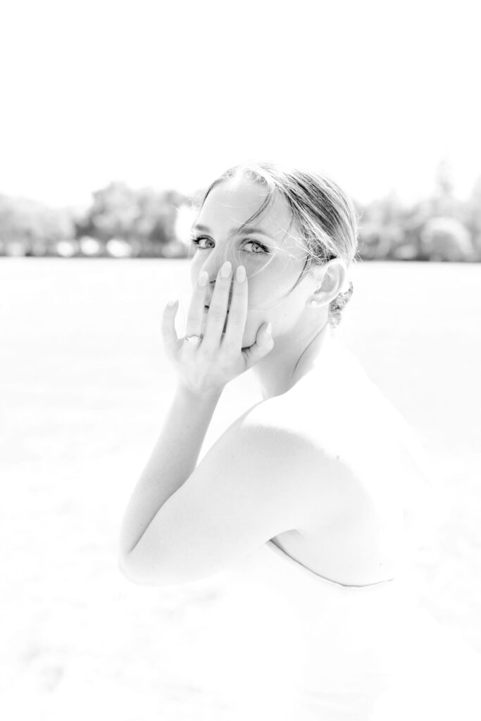 Aesthetic wedding bride puts her hand on the chin and looks at the camera.