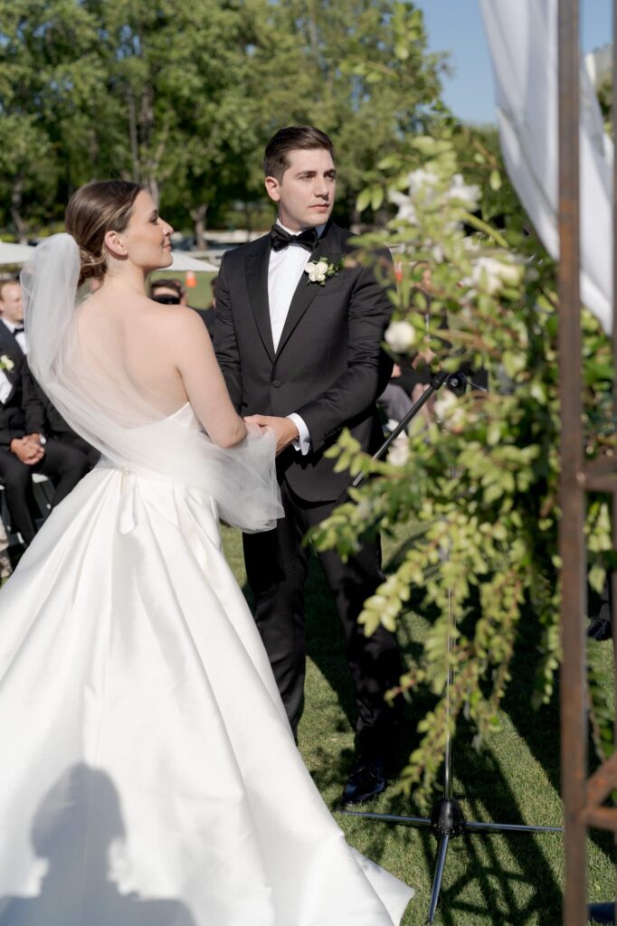 Bride and groom-to-be hold hands and partake in the officiation ceremony.