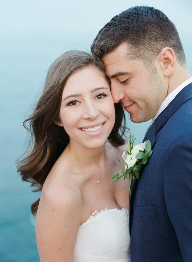 Newly married husband lovingly approaches his wife while she looks at the camera.