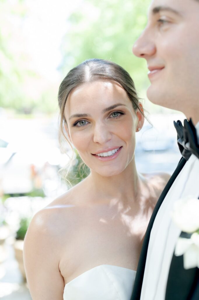 Bride hugs her newly-pronounced husband and smiles at the camera.