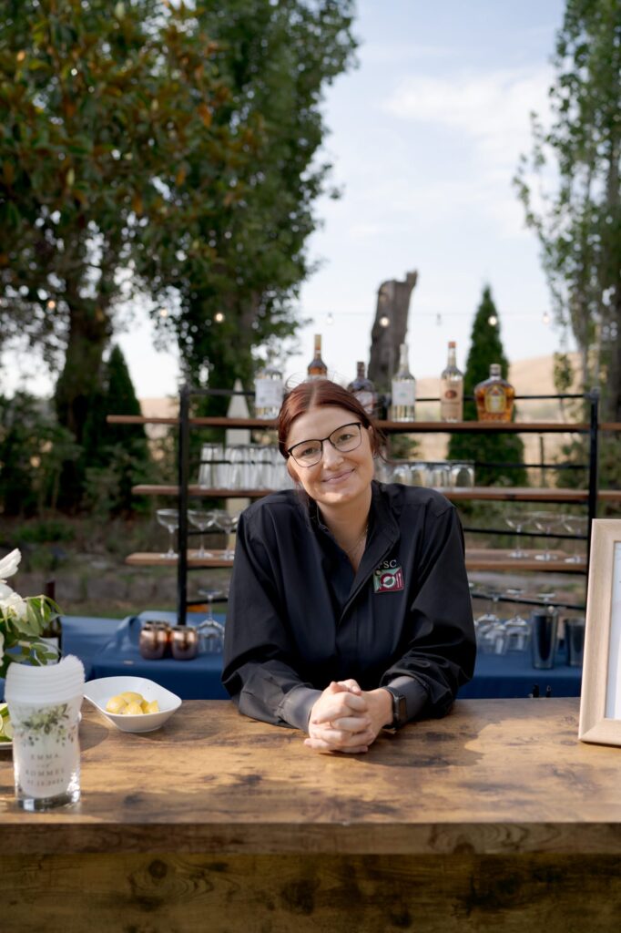 Calm lady wearing glasses smiles gently at Robin Jolin's camera at a Garden Valley Ranch wedding.