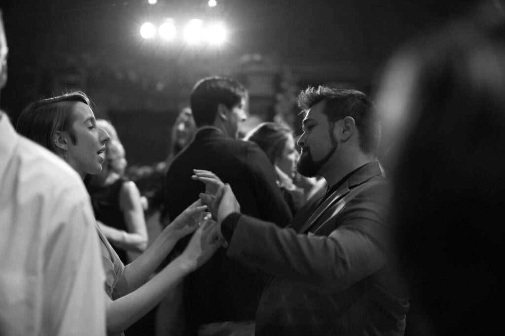 Wedding guests dance under warm lights at the afterparty.