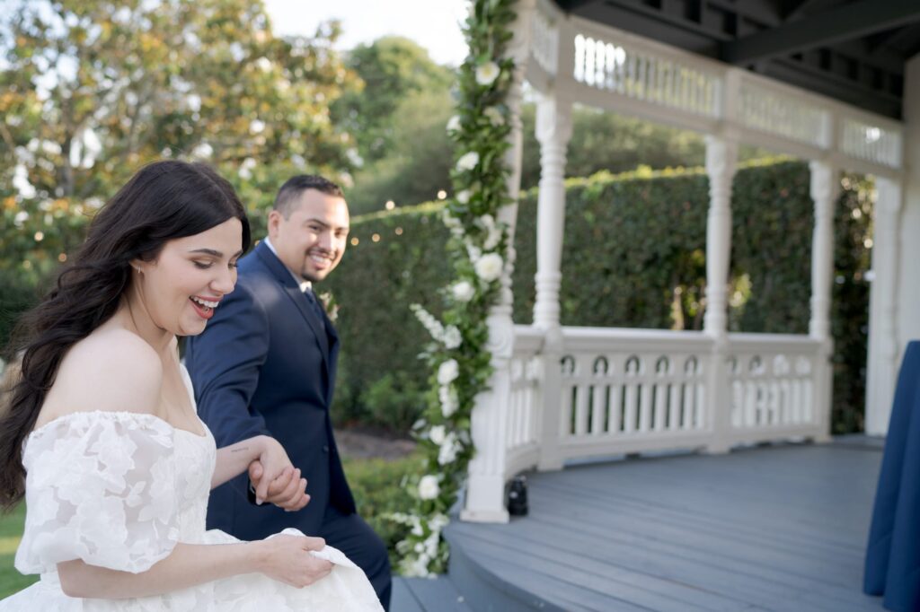 Groom holds the bride's hand and leads her to the reception party ceremony.