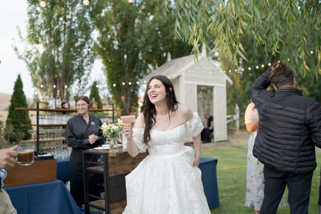 Bride grabs a drink and enjoys her reception party.