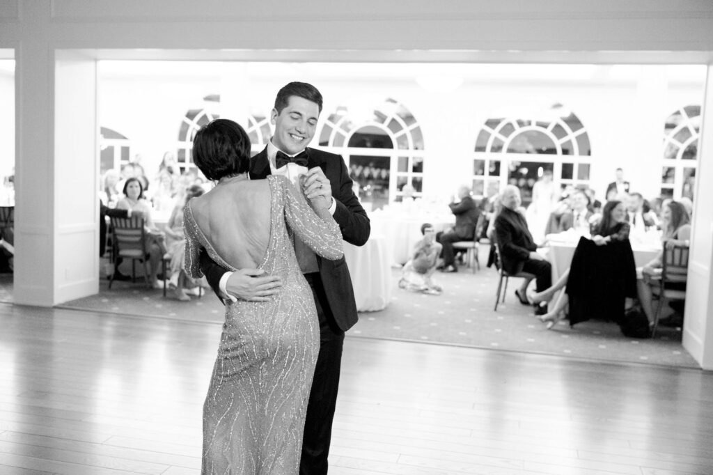 Groom dances with a female guest at the wedding reception party.