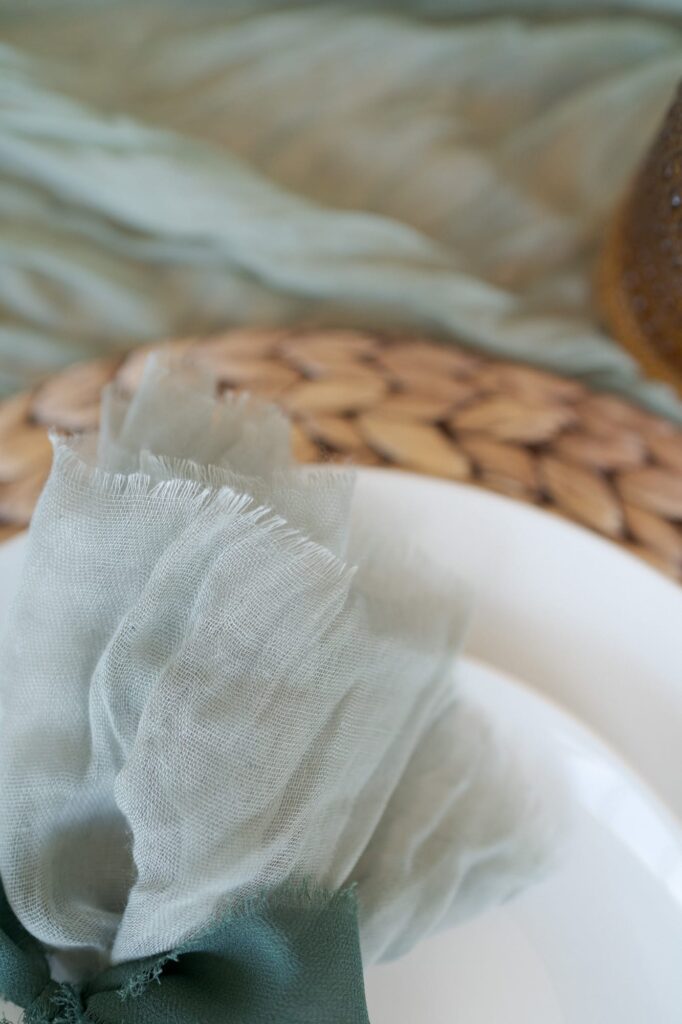 White plate with a hand-knitted placemat and a dining napkin.