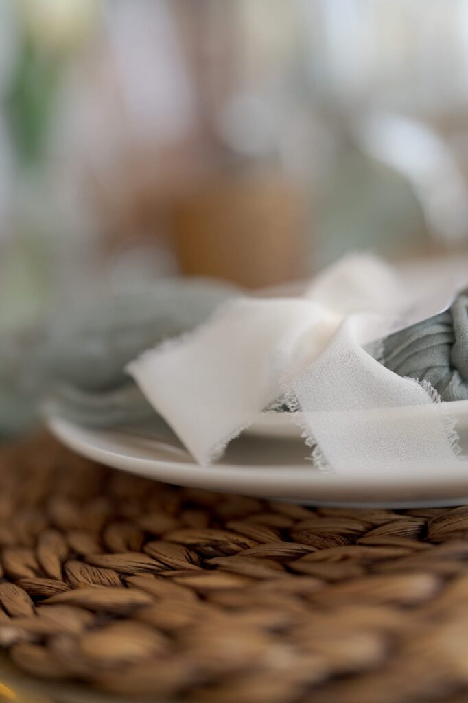 White plate with napkin placed on a round placemat.